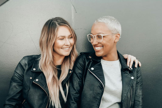 two women wearing black leather jackets smiling